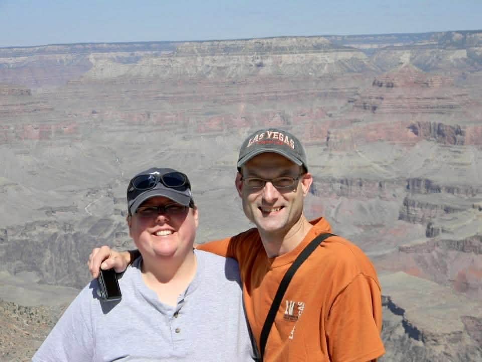 Christina and her brother smiling in front of a canyon