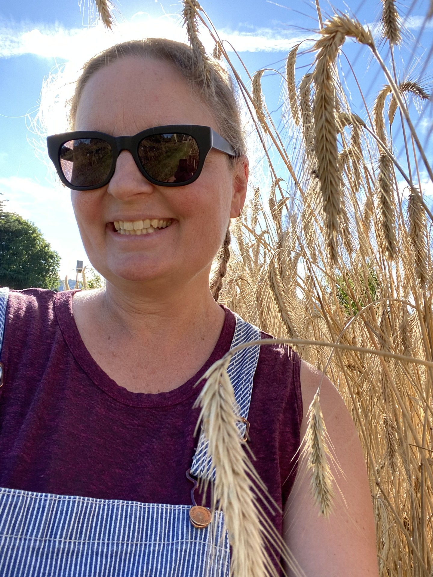 smiling woman with sunglasses in a wheat field 