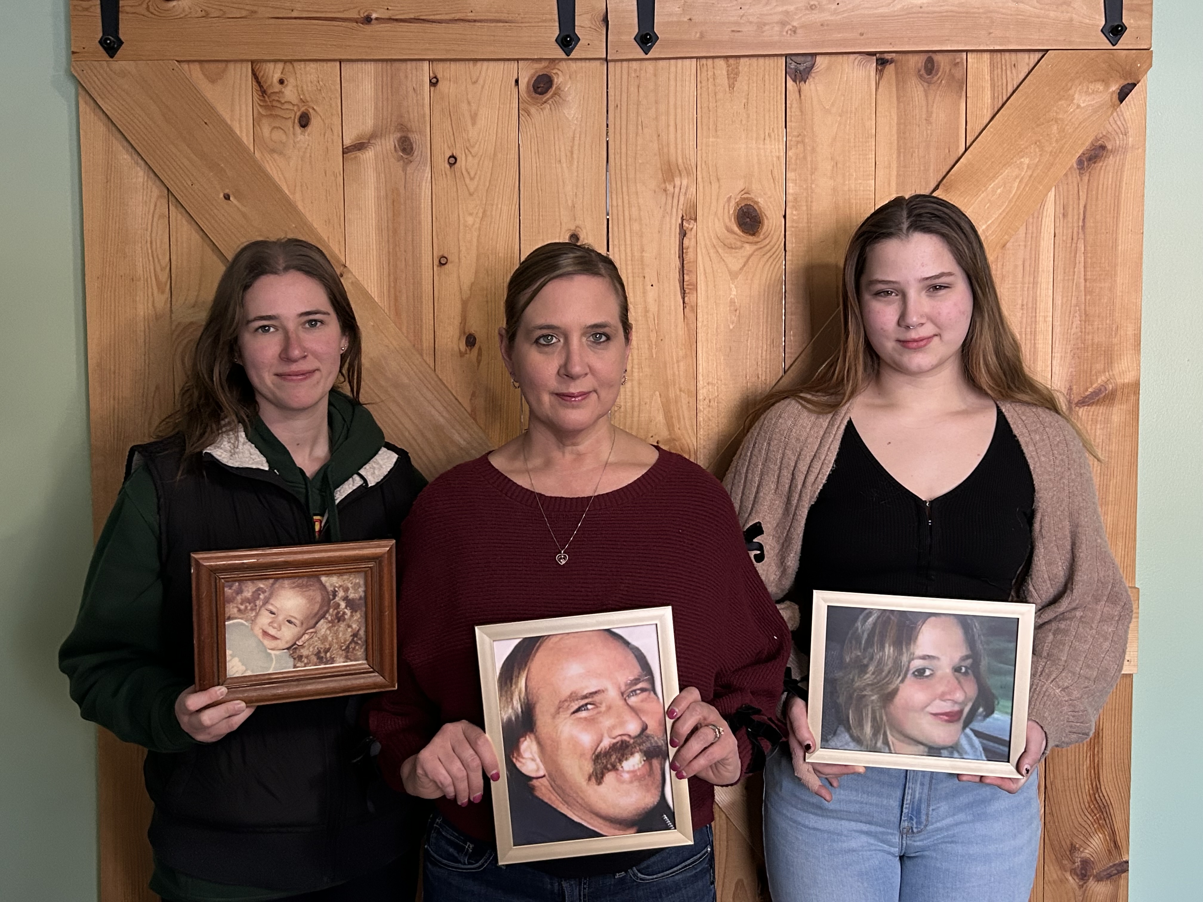 three women holding family photos