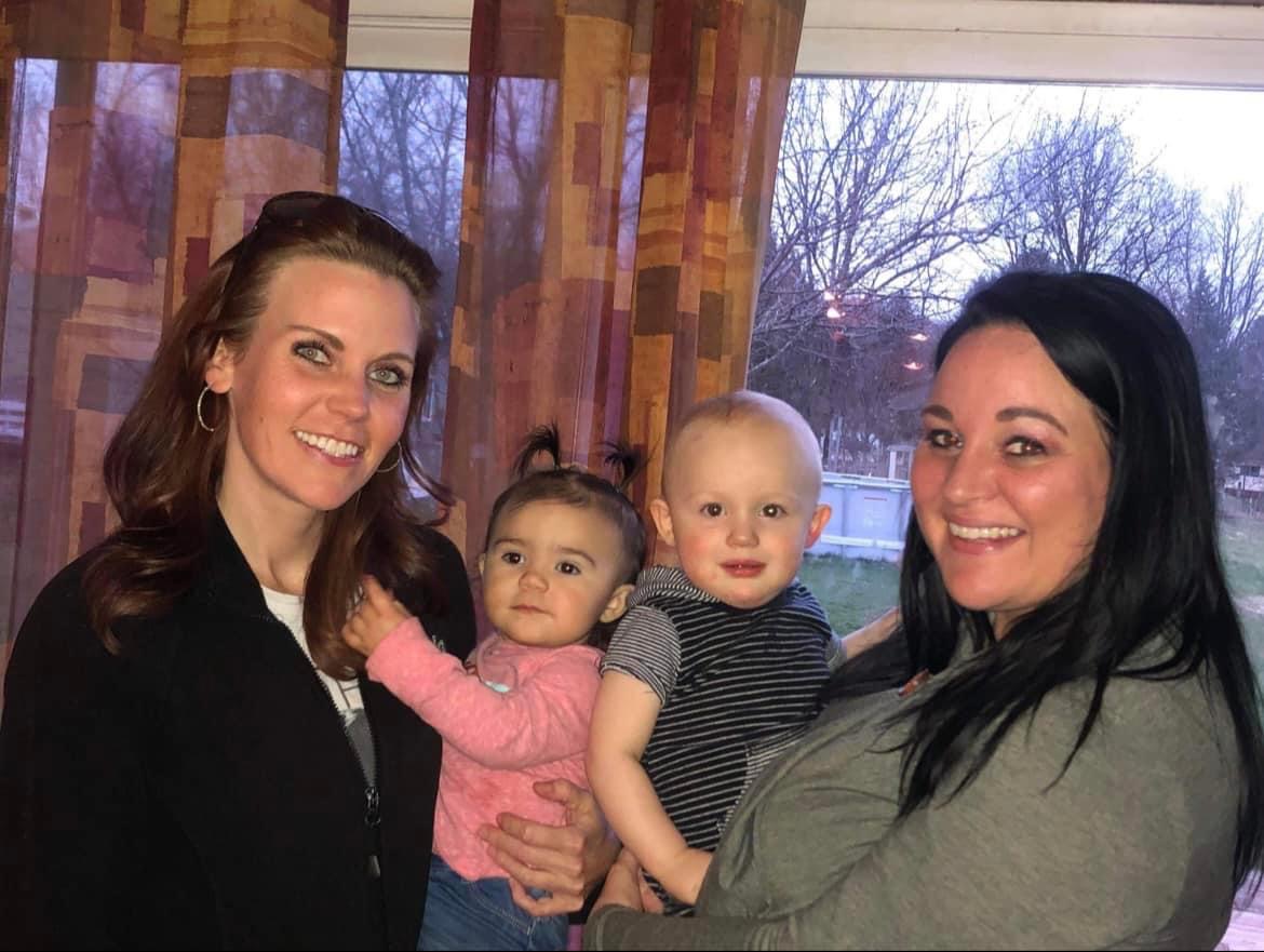 Sarah and Danyel holding young children.