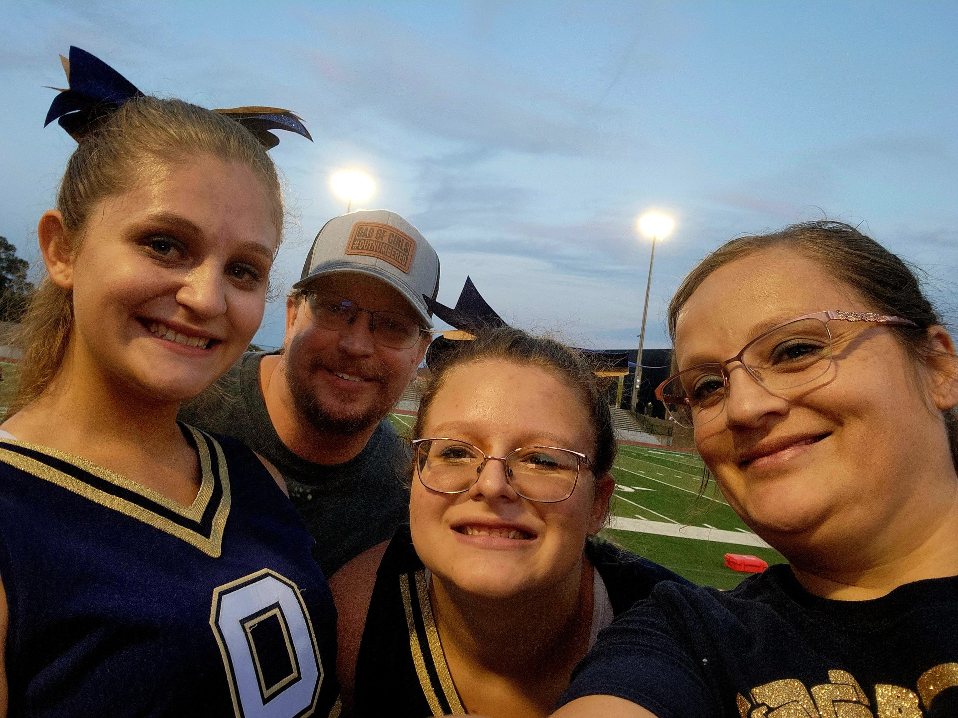 family of four in sports gear smiles at an outdoor field event