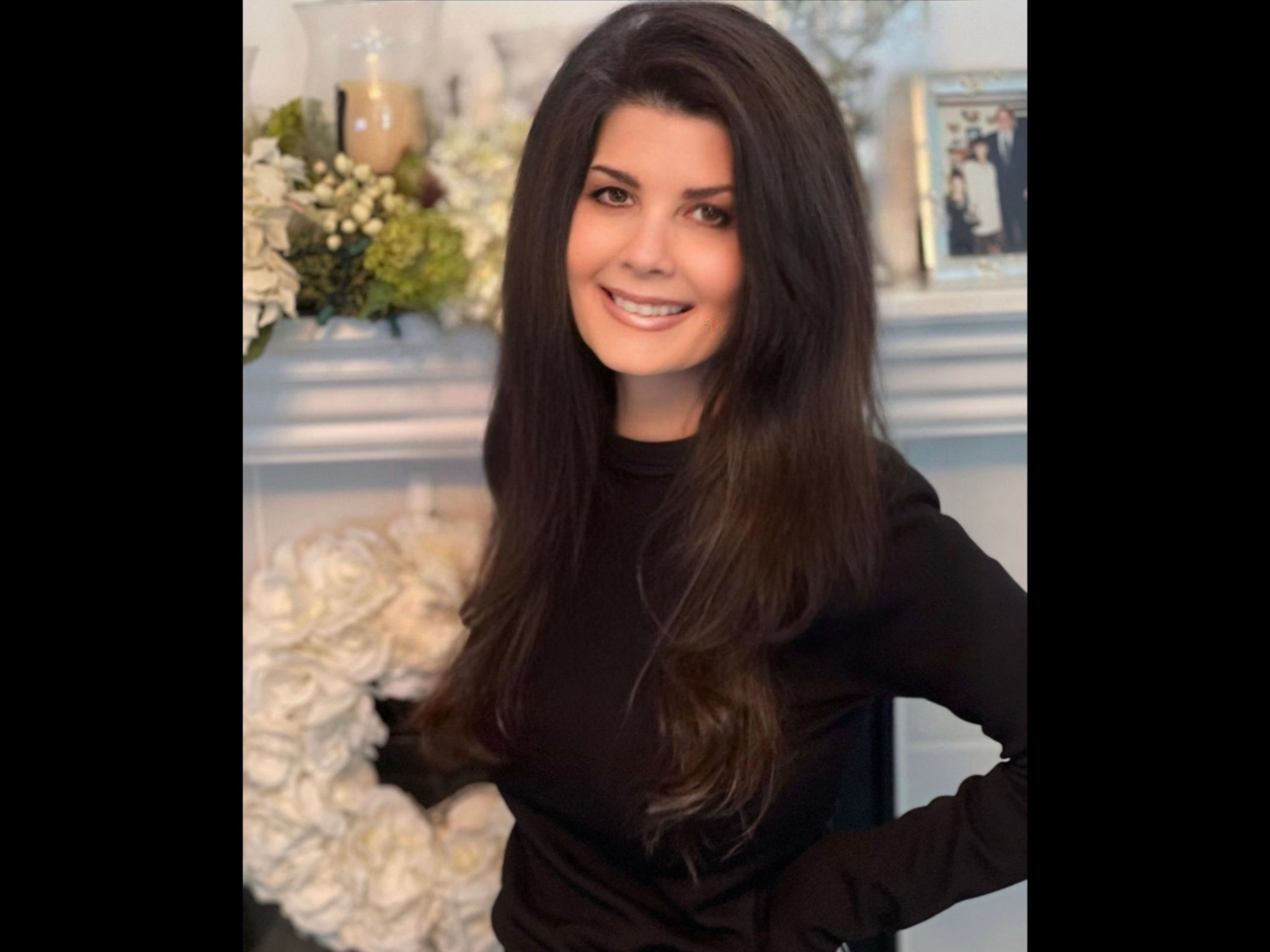 smiling woman in front of mantlepiece