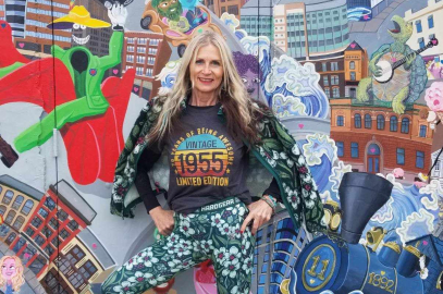 Woman standing in front of a colorful mural.