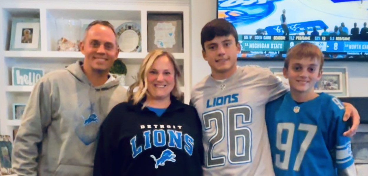 A family and their dogs wearing Detroit Lions gear 