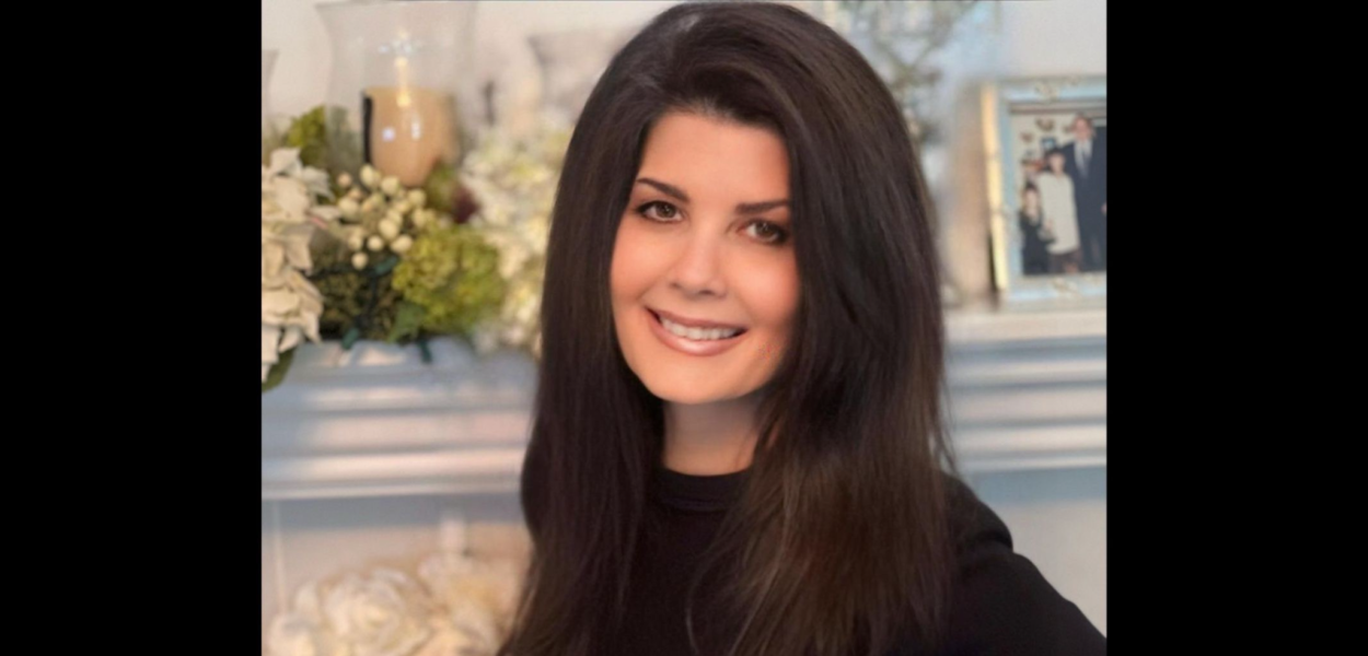 smiling woman in front of mantlepiece
