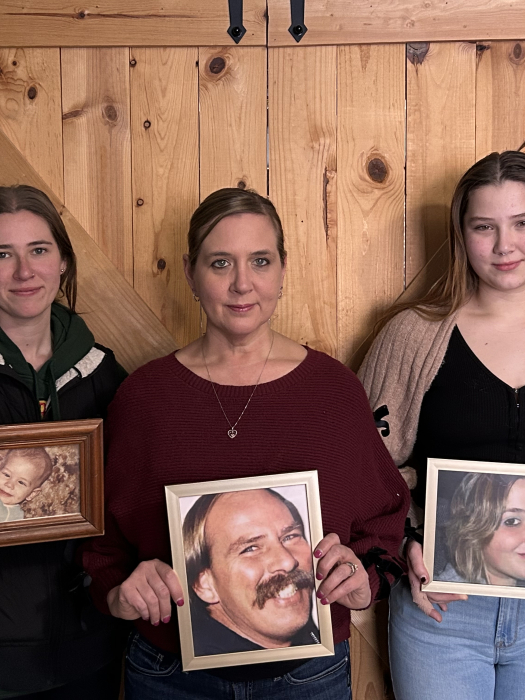 three women holding family photos