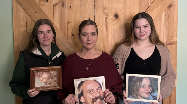 three women holding family photos
