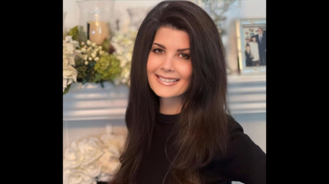smiling woman in front of mantlepiece